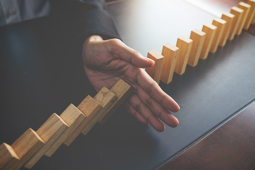 problem solving close up view hand business woman stopping falling blocks table concept about taking responsibility.